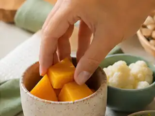 Mão escolhendo um alimento para começar.